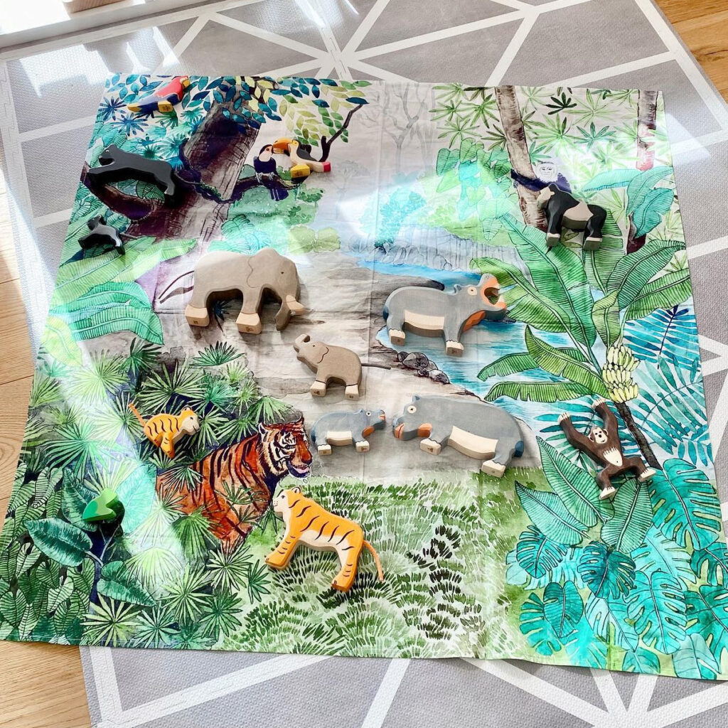 Wooden animals on a jungle cloth